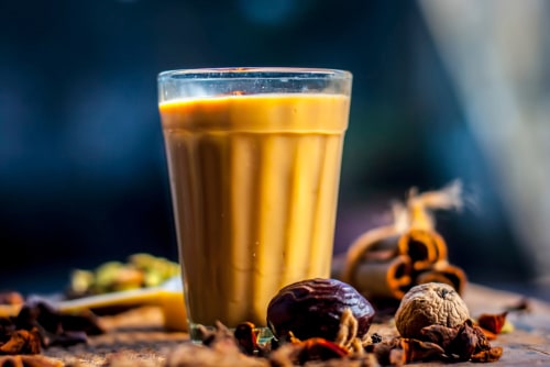  IndianAsian drink Masala Chai or Spicy tea with all the ingredients including sugar on a wooden surface. For facts About India.