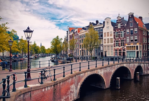 Beautiful view of Amsterdam canals with bridge and typical dutch houses. Holland.