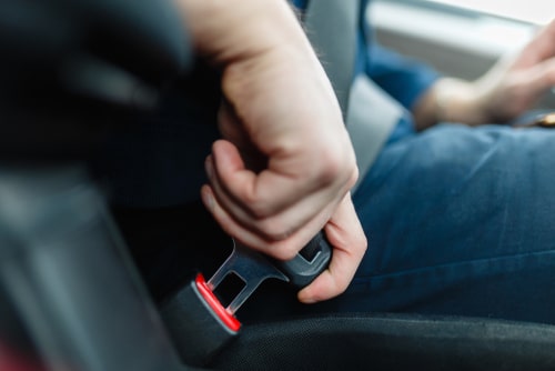 Men's hand fastens the seat belt of the car. Interesting facts about cars.