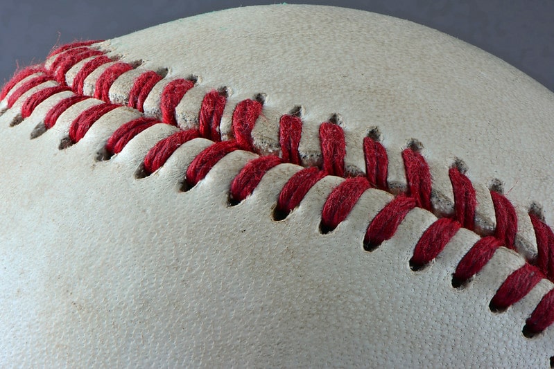 a baseball with beautiful red stitches