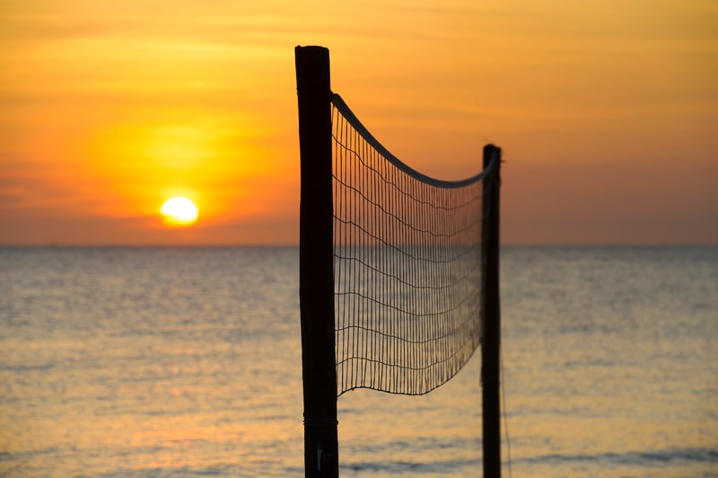 A volleyball net at sunset on a tropical beach. For volleyball facts and trivia
