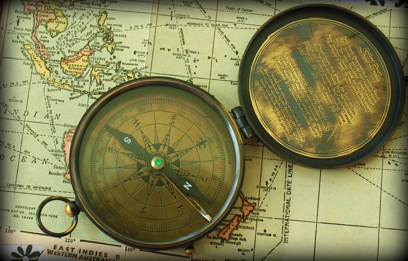 Vintage compass on a vintage map. about maps and globes