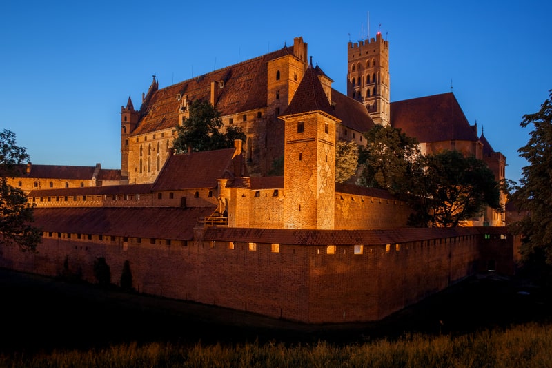 Malbork Castle by night in Poland, medieval fortress built by the Teutonic Knights, the largest brick castle in the world.