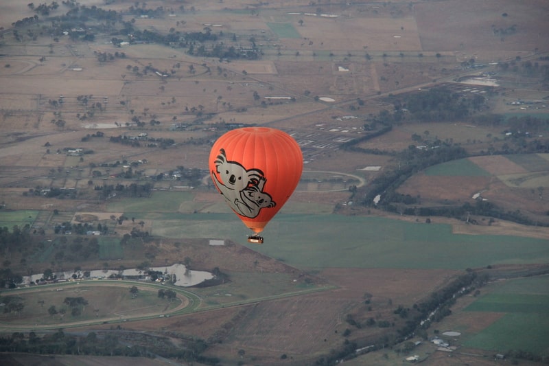 Hot Air Balloon rising high over landscape